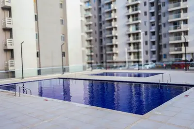a swimming pool in front of some tall buildings at New modern apartment in Barranquilla