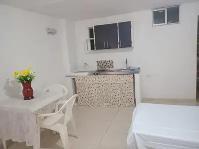 a kitchen with a table and a sink and a table and chairs at Apartaestudio Barranquilla Calle 87 in Barranquilla