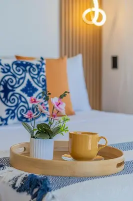 a tray with a coffee cup and flowers on a bed at CB1530 Hermosa Suite en Crespo Vista 180º in Cartagena de Indias