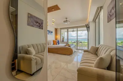 two views of a living room with a couch and a bed at CB1530 Hermosa Suite en Crespo Vista 180º in Cartagena de Indias