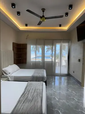 a bedroom with two beds and a ceiling fan at Cabaña Aledan in Coveñas