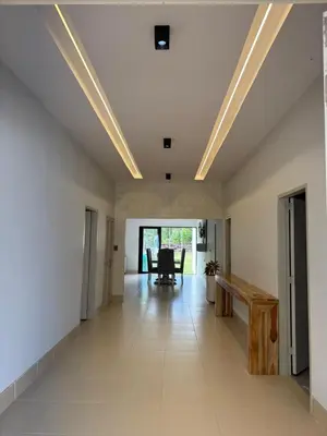 a large room with white walls and a ceiling with lights at Cabaña Aledan in Coveñas