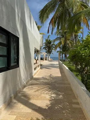 a sidewalk next to a building with palm trees at Cabaña Aledan in Coveñas