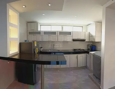 a kitchen with white cabinets and a black counter top at Apartamento para estrenar in Barranquilla