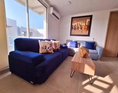 a living room with a blue couch and a table at Cartagena playa uso exclusivo Serena del mar in Cartagena de Indias