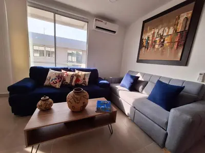 a living room with a blue couch and a table at Cartagena playa uso exclusivo Serena del mar in Cartagena de Indias
