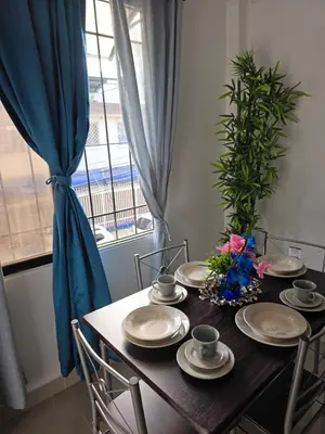a dining room table with plates and flowers on it at Hermoso estudio cerca del Centro Histórico in Cartagena de Indias