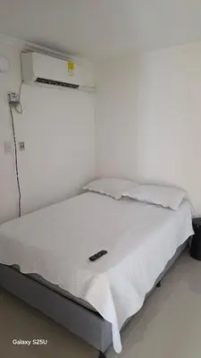 a bed in a room with a white wall at Hermoso estudio cerca del Centro Histórico in Cartagena de Indias