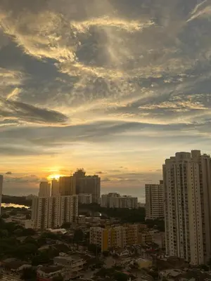 a view of a city with the sun setting behind buildings at ÁME Living in Cartagena de Indias