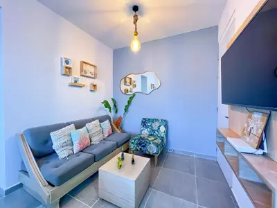 a living room with a blue couch and a tv at Cielo Caribe 501 in Coveñas