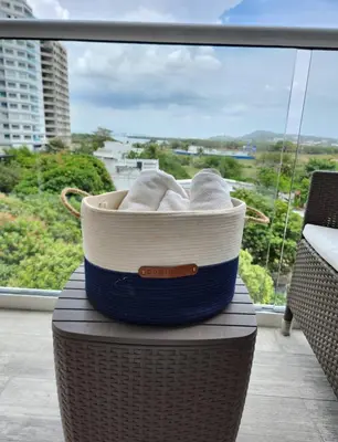 a basket of towels sitting on a table in front of a window at 1 bedroom luxury apartment with private jaccuzi in Cartagena de Indias
