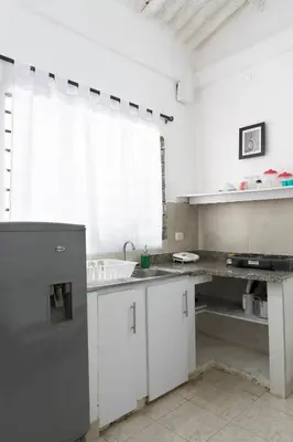 a white kitchen with a sink and a counter at Hotel Villa Ivel in Turbaco