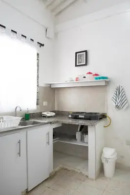 a white kitchen with a sink and a counter at Hotel Villa Ivel in Turbaco