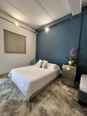 a bedroom with a bed and a blue wall at Calma Hospedaje in Turbaco