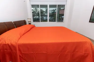 an orange bed in a room with a window at Casa La Altamar in Coveñas
