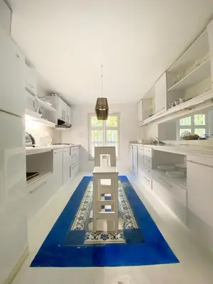 a kitchen with white cabinets and a blue rug on the floor at Apartment in the Historical Center of Cartagena in Cartagena de Indias