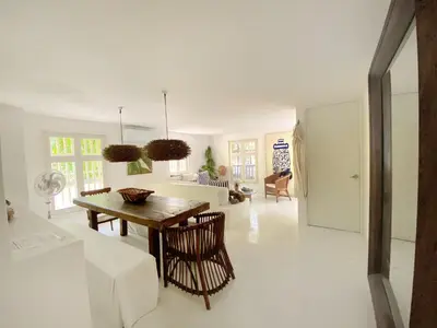 a white living room with a wooden table and chairs at Apartment in the Historical Center of Cartagena in Cartagena de Indias
