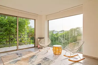 a room with two chairs and a table and large windows at Casa BaruGrande in Cartagena de Indias