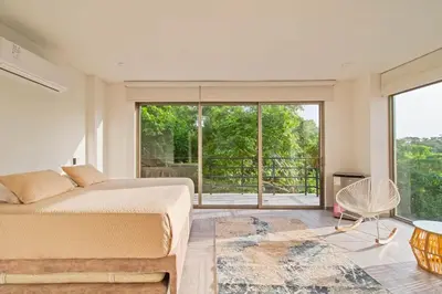 a bedroom with a bed and a large window at Casa BaruGrande in Cartagena de Indias