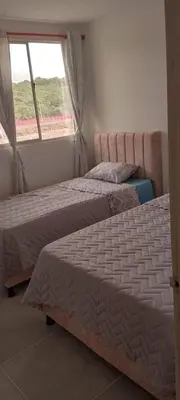 two beds in a room with a window at Encanto de Serena in Manzanillo del Mar