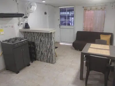 a kitchen and living room with a stove and a couch at Alojamiento independiente, sencillo y acogedor in Barranquilla