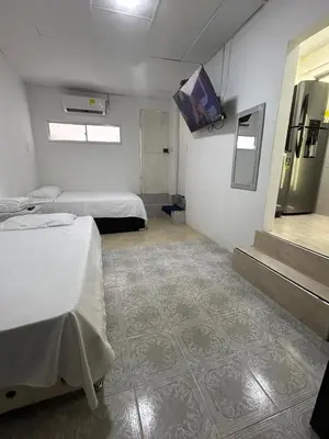 a room with two beds and a tv on the wall at acogedor aparta estudio in Cartagena de Indias