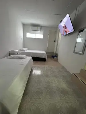 a room with two beds and a tv on the wall at acogedor aparta estudio in Cartagena de Indias