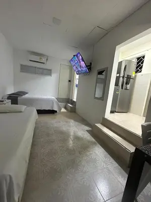 a room with two beds and a tv on the wall at acogedor aparta estudio in Cartagena de Indias