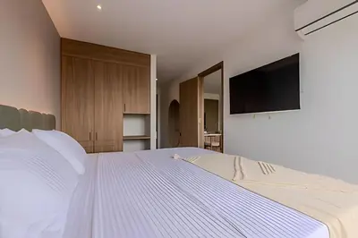 a bedroom with a white bed with a flat screen tv at 1 k Baia Kristal lujoso y nuevo 2 alcobas Prive 2 in Cartagena de Indias