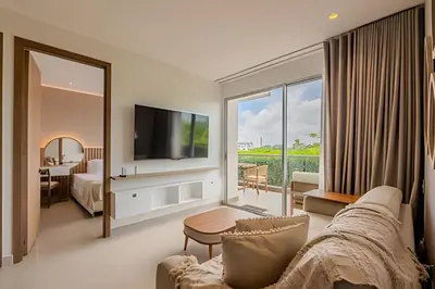a living room with a couch and a tv and a bedroom at 1 k Baia Kristal lujoso y nuevo 2 alcobas Prive 2 in Cartagena de Indias