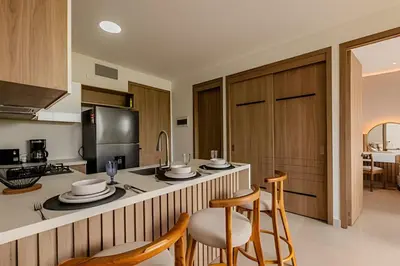 a kitchen with wooden cabinets and a counter with chairs at 1 k Baia Kristal lujoso y nuevo 2 alcobas Prive 2 in Cartagena de Indias