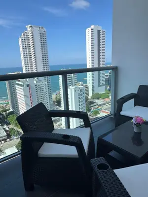a balcony with chairs and a table and a view of the city at Vista Preciosa desde el piso 23 Apartamento frente al mar in Cartagena de Indias