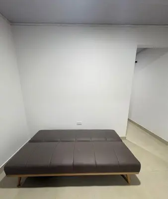 a black bed in a room with a white wall at Maru Apartamentos #4 in Cartagena de Indias