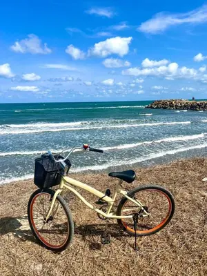 a bike parked on the beach near the ocean at Beachfront Apartment - Pool - Jacuzzi - Wi-Fi in Cartagena de Indias