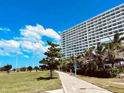 a tall building with a tree in front of it at Beachfront Apartment - Pool - Jacuzzi - Wi-Fi in Cartagena de Indias
