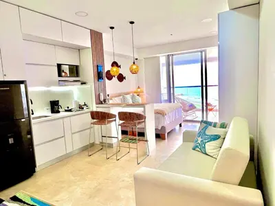 a kitchen and living room with a couch and a table at Beachfront Apartment - Pool - Jacuzzi - Wi-Fi in Cartagena de Indias