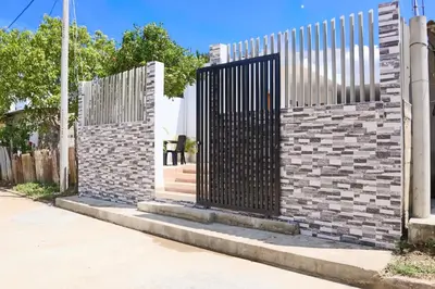 a gate on the side of a brick wall at Habitacion Manglares 101 in Coveñas