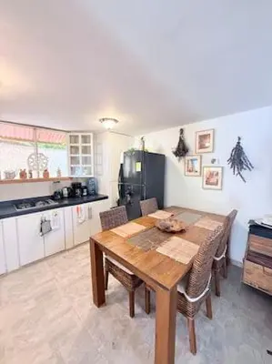 a kitchen with a wooden table and chairs in a kitchen at Tropical Nomad Hub - Pool - Super Fast Wi-Fi in Santa Veronica
