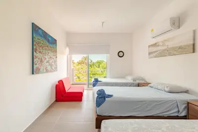 a bedroom with two beds and a red chair at Vacation Home Escape & Villa with pool in El Morro