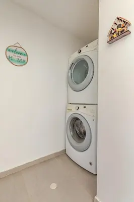a washer and dryer in a white laundry room at Vacation Home Escape & Villa with pool in El Morro