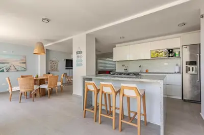 a kitchen and dining room with a counter and chairs at Vacation Home Escape & Villa with pool in El Morro