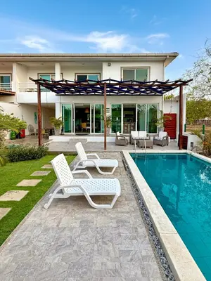 a house with a swimming pool and two lounge chairs at Vacation Home Escape & Villa with pool in El Morro