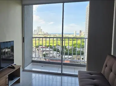 a living room with a large window with a view of a city at Hermoso apartamento cerca a las playas de Marbella in Cartagena de Indias