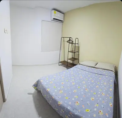 a bedroom with a bed with a blue comforter at Hermoso apartamento cerca a las playas de Marbella in Cartagena de Indias