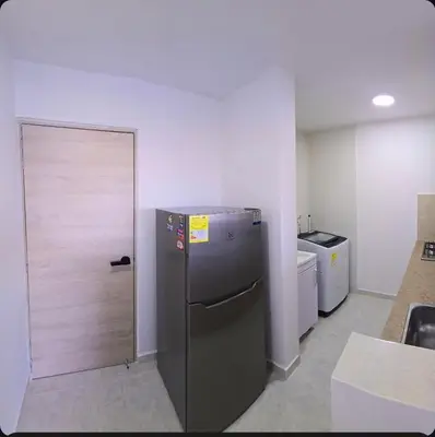 a kitchen with a refrigerator and a door at Hermoso apartamento cerca a las playas de Marbella in Cartagena de Indias