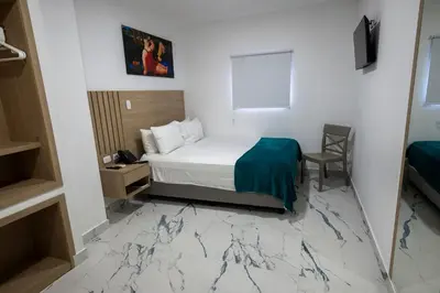 a hotel room with a bed and a table and a chair at Hotel Serenity Inn in Cartagena de Indias
