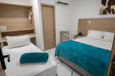 a hotel room with two beds with blue sheets at Hotel Serenity Inn in Cartagena de Indias