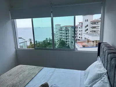 a bedroom with a bed and a view of the ocean at Apartamento con vista al mar en Bello Horizonte, Santa Marta in Santa Marta