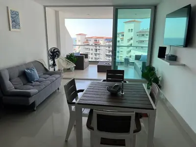 a living room with a table and a couch at Apartamento con vista al mar en Bello Horizonte, Santa Marta in Santa Marta