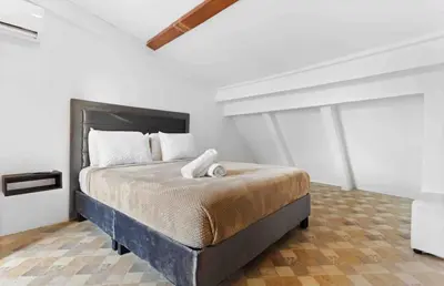 a bedroom with a large bed in a white room at Casa Trinidad Getsemaní Hotel in Cartagena de Indias